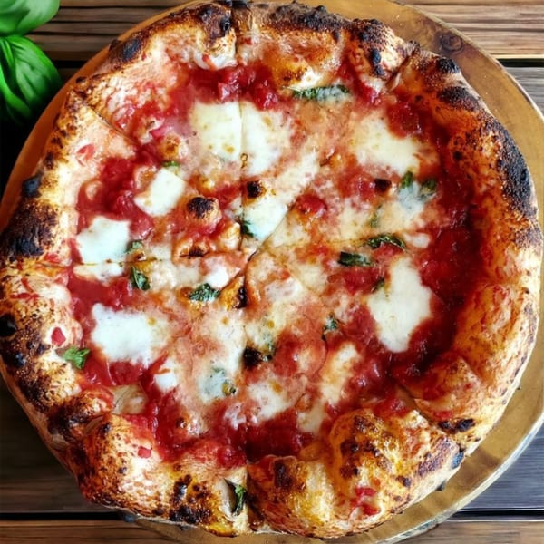 A freshly baked Crab Rock PIZZA with rich red sauce, melted mozzarella, and basil on a wooden board.